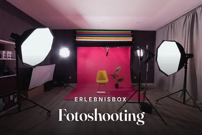 Photo studio with softbox lights, pink backdrop and a yellow chair, overlaid with the title Erlebnisbox Fotoshooting