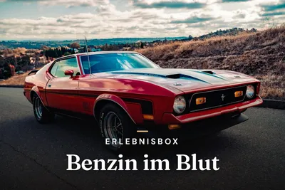 Red classic muscle car with black stripes on a country road