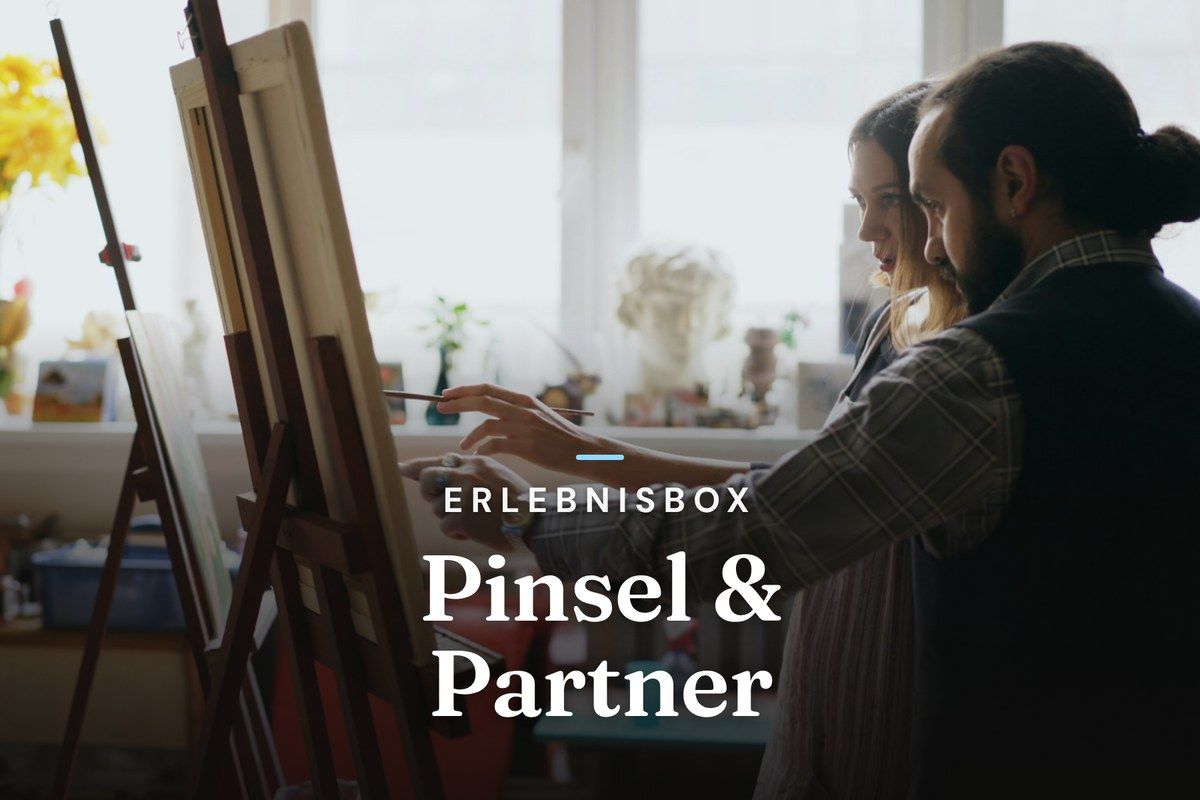 Couple painting together at an easel in a bright art studio