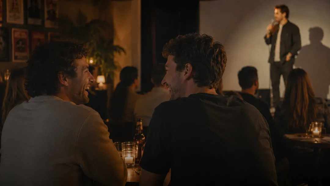 Two friends laughing at a bar