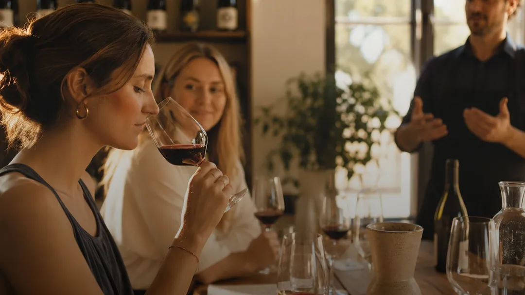 A woman smelling wine