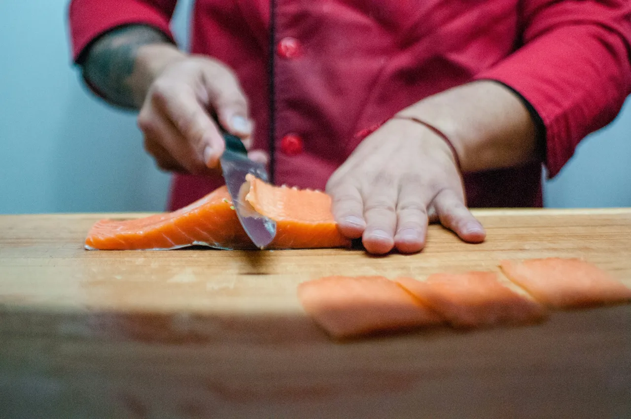 A person cutting fish