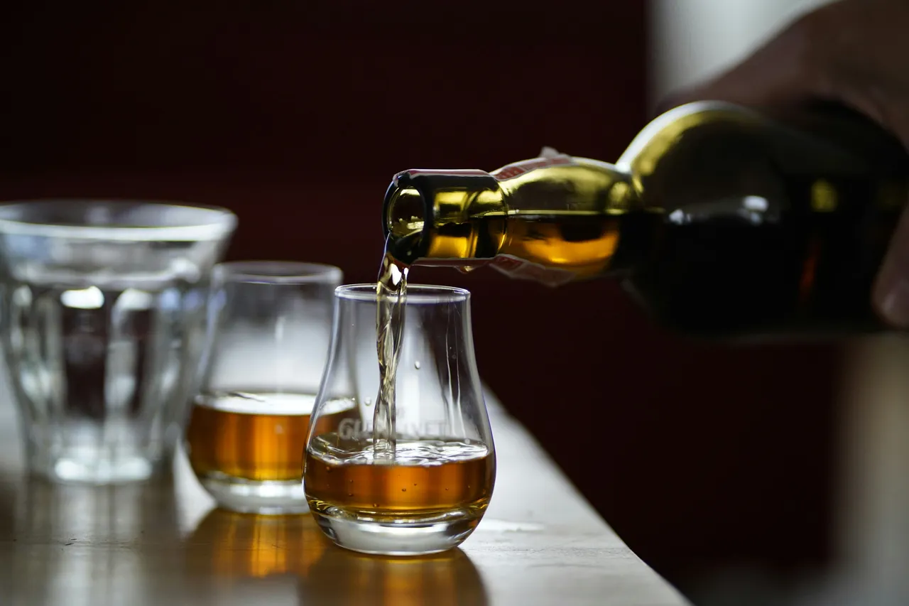 Whisky getting poured in 2 glasses