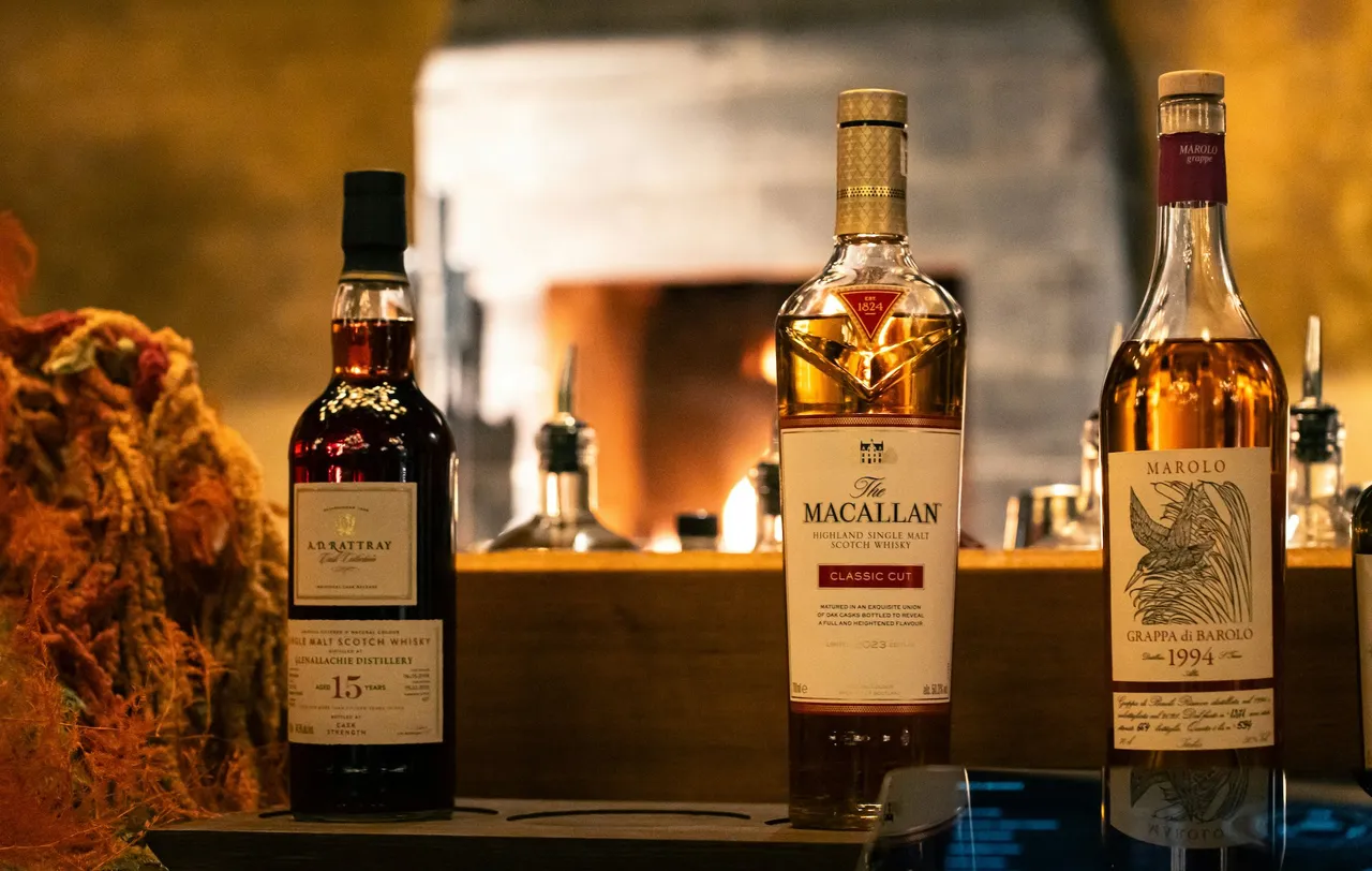 Three bottles of whisky standing on a table in a bar setting