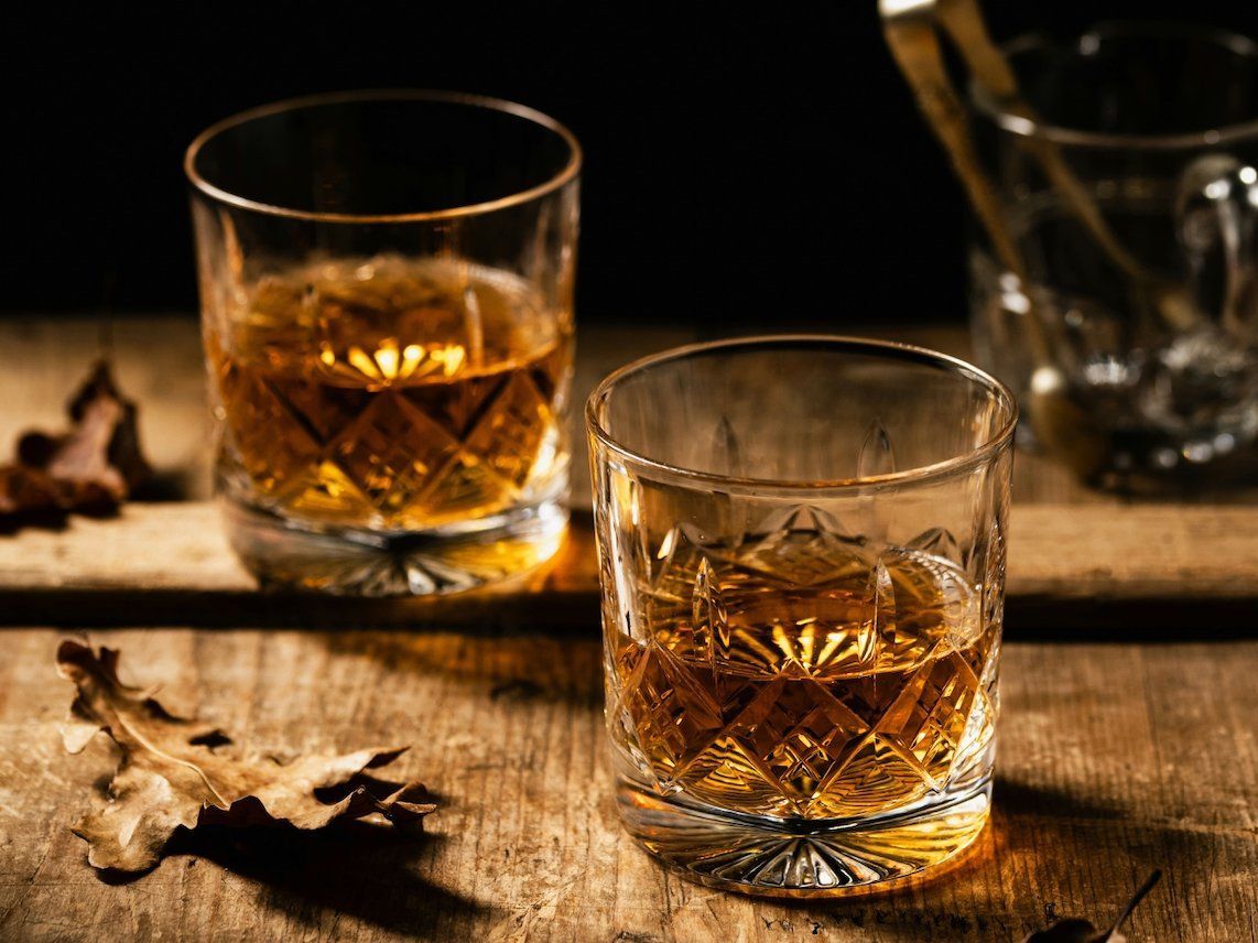 Two glasses of whisky in autumn setting