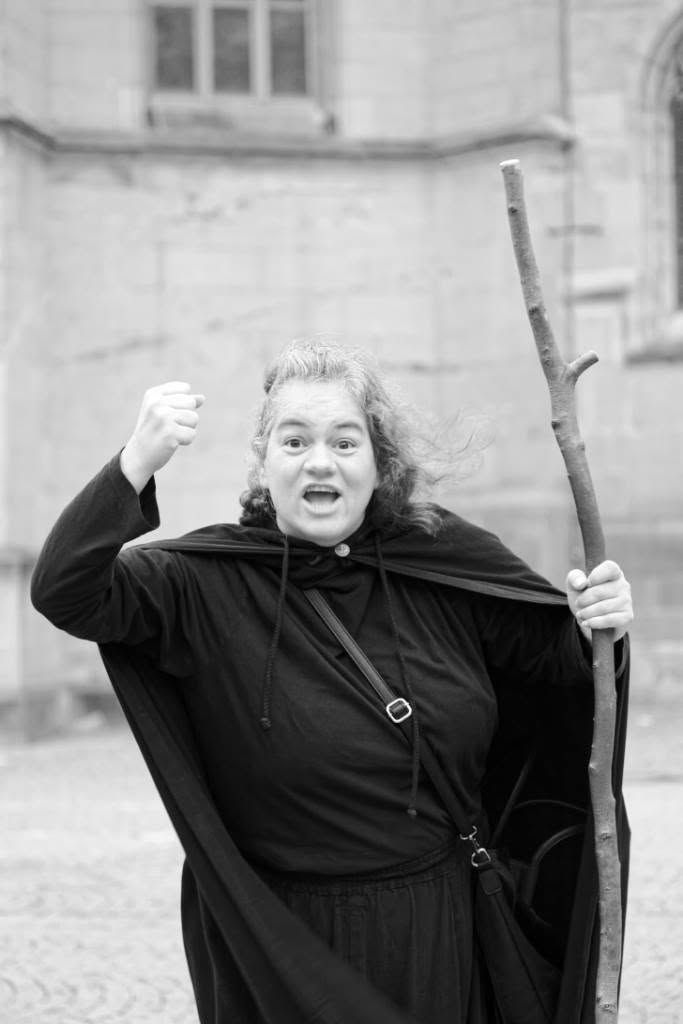 A woman in a spooky costume explaining something