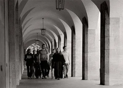 A group of people on a tour being let by a woman in a spooky costume