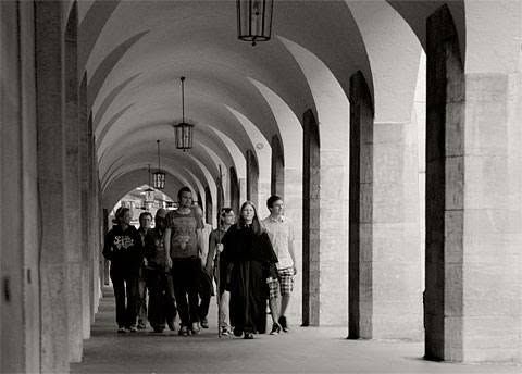 A group of people on a tour being let by a woman in a spooky costume