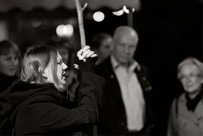 A woman in a spooky costume explaining something to a group of people