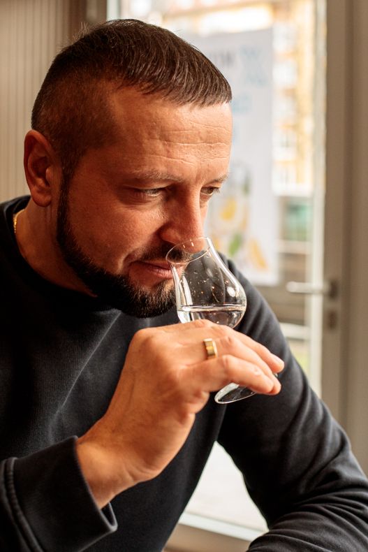 Close-up of a man nosing a glass of gin during a tasting session.