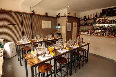 Bar room set up for a gin tonic tasting event, with high tables, glassware, and fresh citrus fruits.