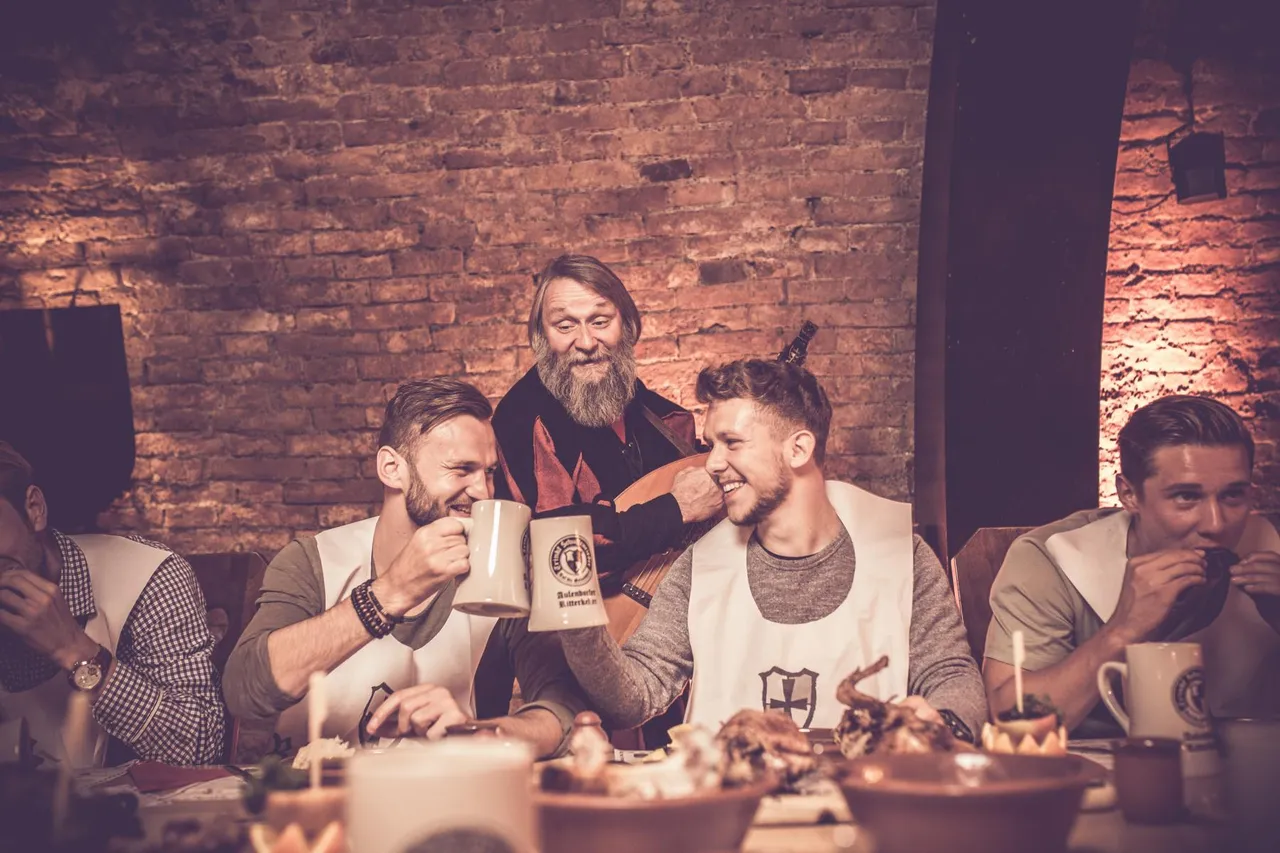 Guests laughing and toasting at the medieval feast table