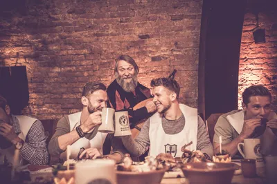 Guests laughing and toasting at the medieval feast table