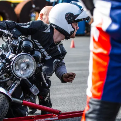 A person applying the hang-off technique on a motorbike