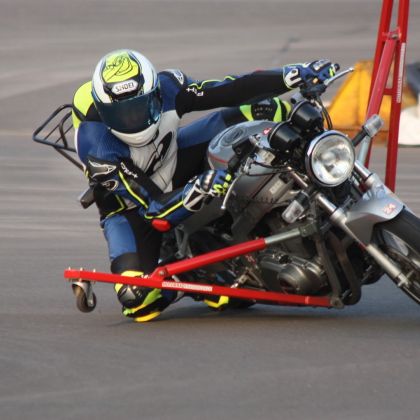 A person applying the hang-off technique on a motorbike