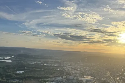 View from a helicopter over the countryside at sunset with golden clouds