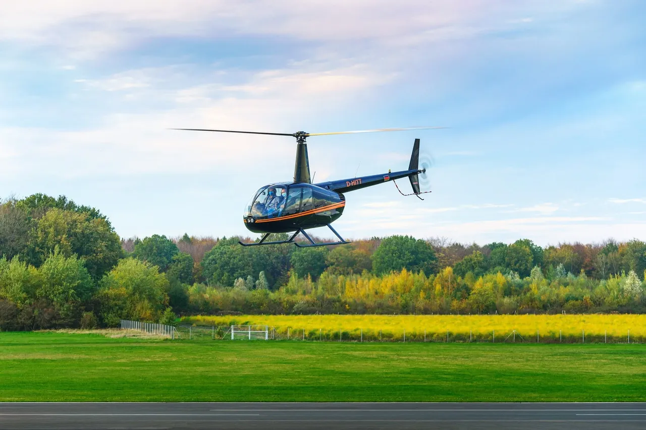 Helicopter flying low over green fields and trees at the start of a sightseeing flight