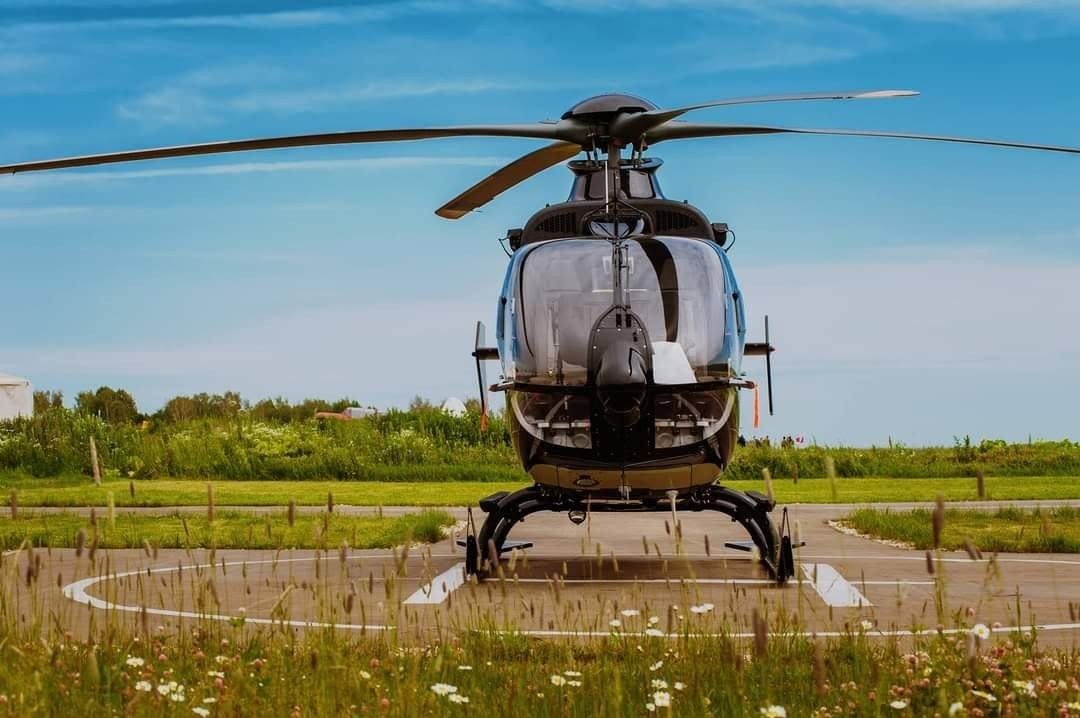 Front view of a helicopter standing on a grass airfield in summer