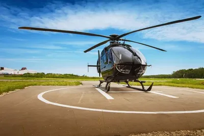 Helicopter waiting on the helipad on a sunny day, ready for a sightseeing flight