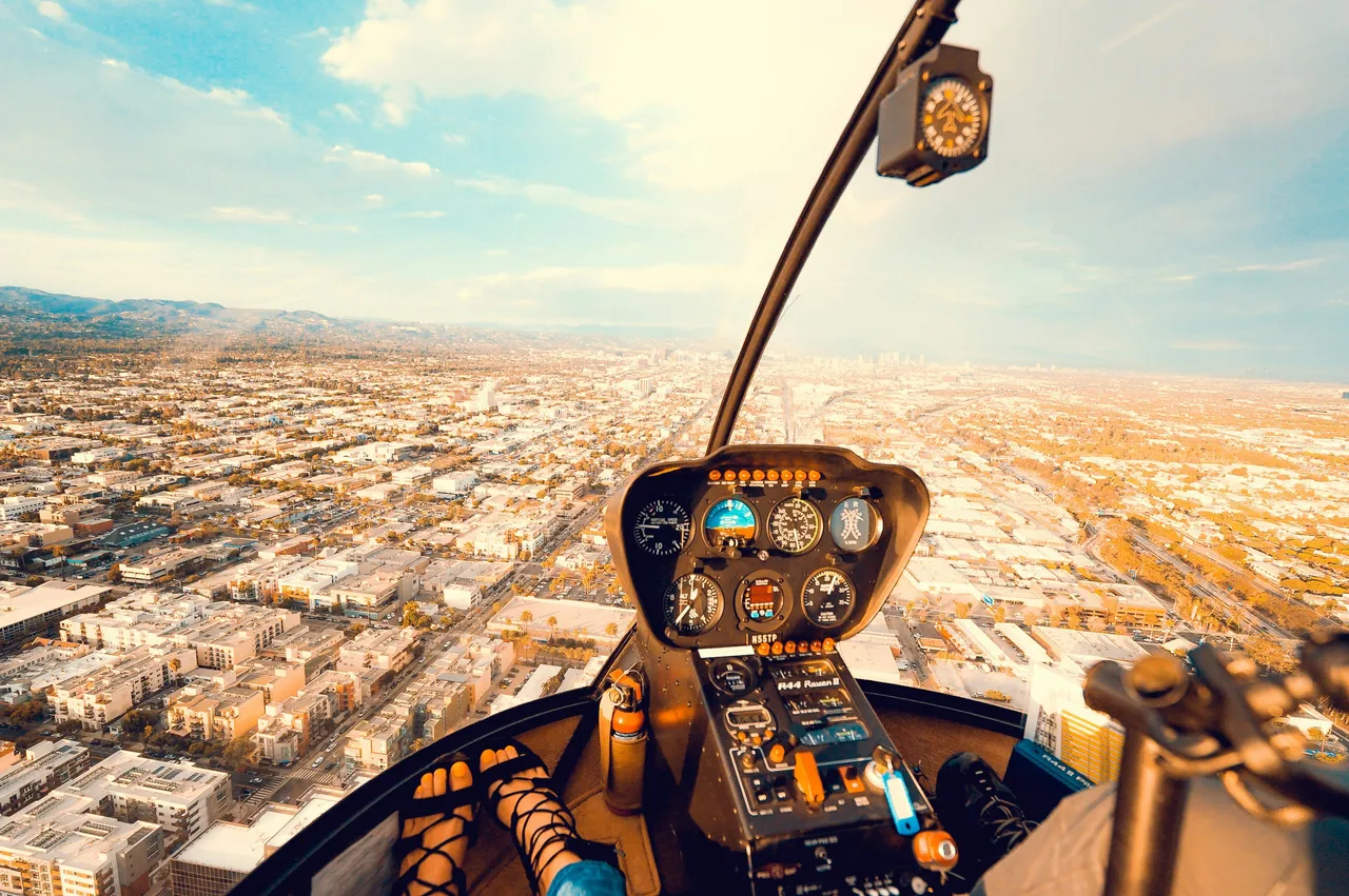 view of the inside of a helicopter over a city
