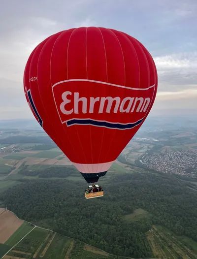 Red hot air balloon flying over the landscape