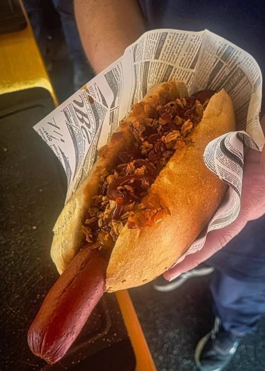 A person holding a hot dog