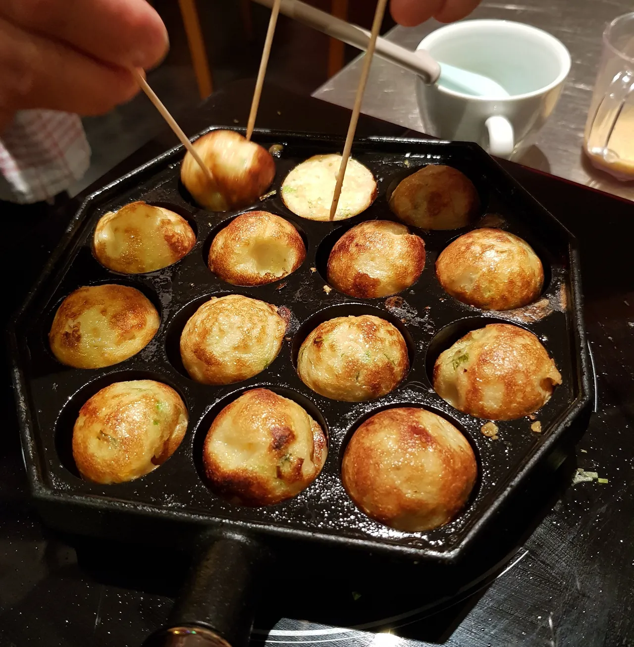 Japanese takoyaki balls cooking in a pan