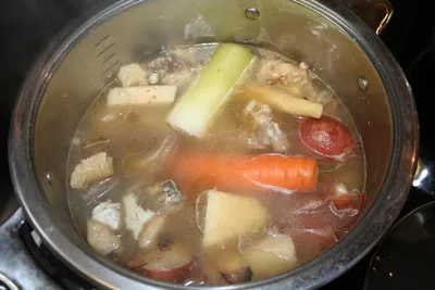 Homemade broth with vegetables simmering in a pot
