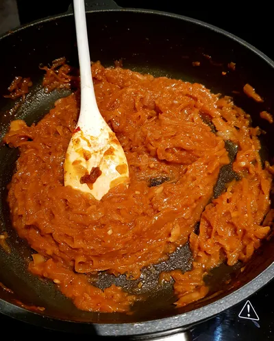 Onion sauce simmering in a frying pan