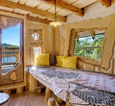 Cozy lounge with cushioned bench, yellow pillows and large windows overlooking the lake