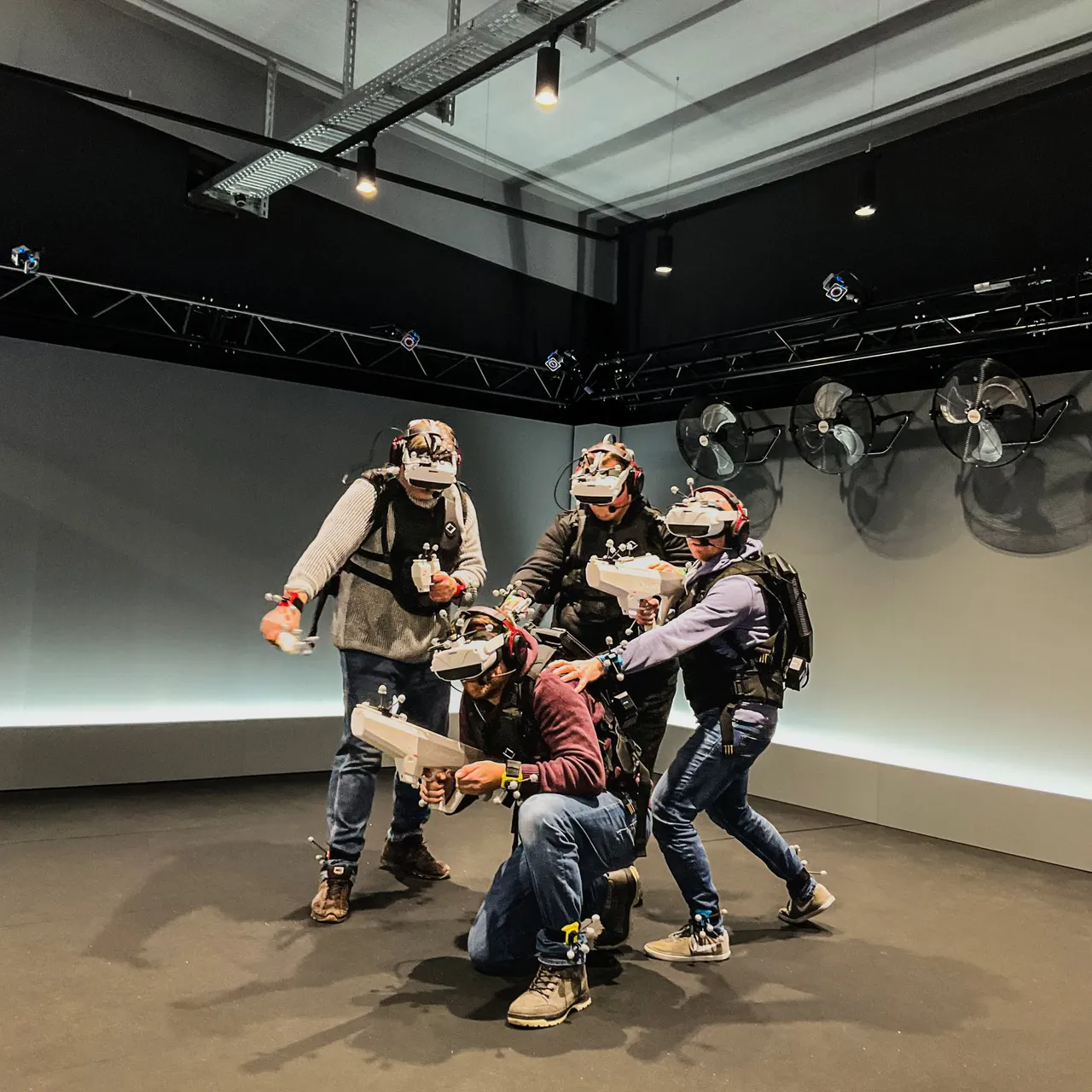 A group of people with VR glasses and lasertag guns