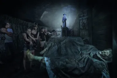Family reacting to a dark, eerie underground scene featuring a shrouded body and a hooded lantern-carrying figure.