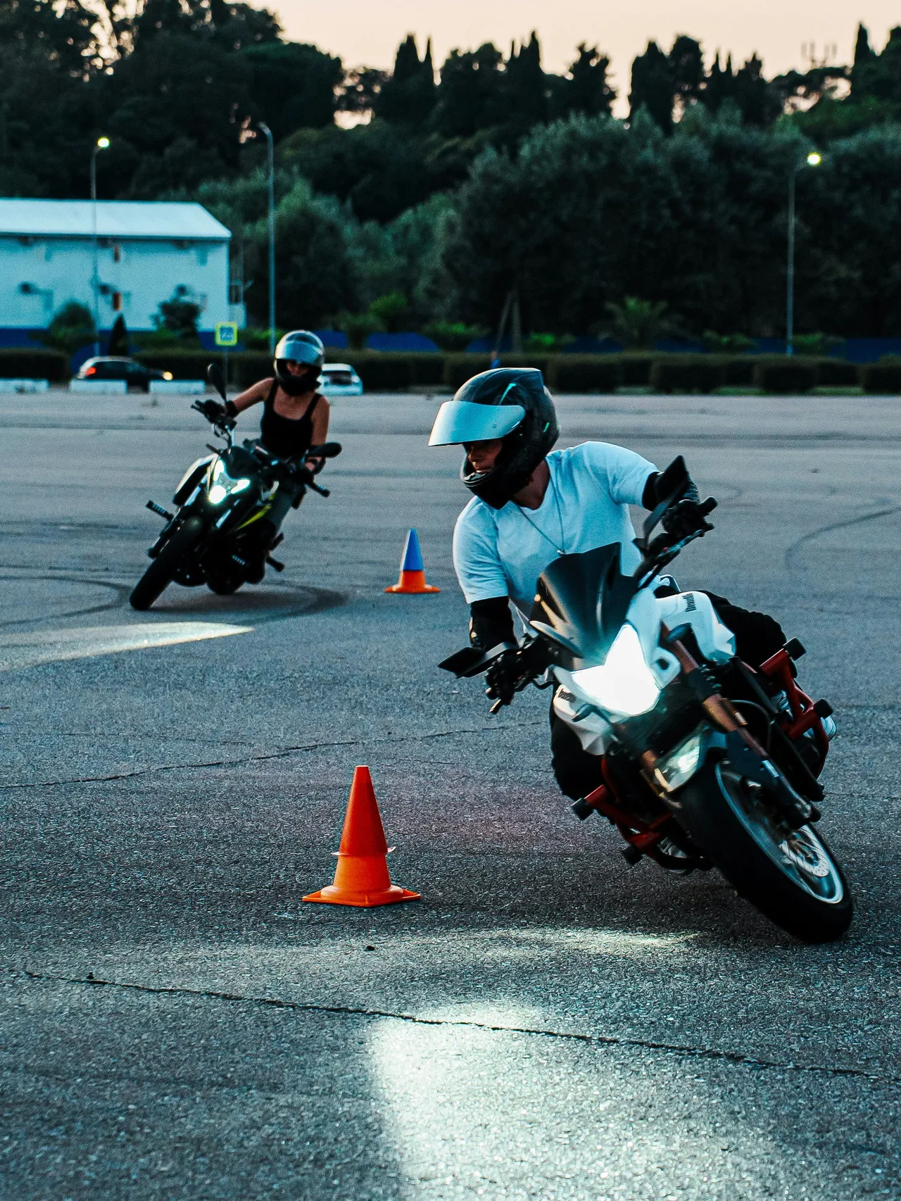 A man wearing a full-face helmet and protective gear riding a bright yellow sport motorcycle on a curved paved road.