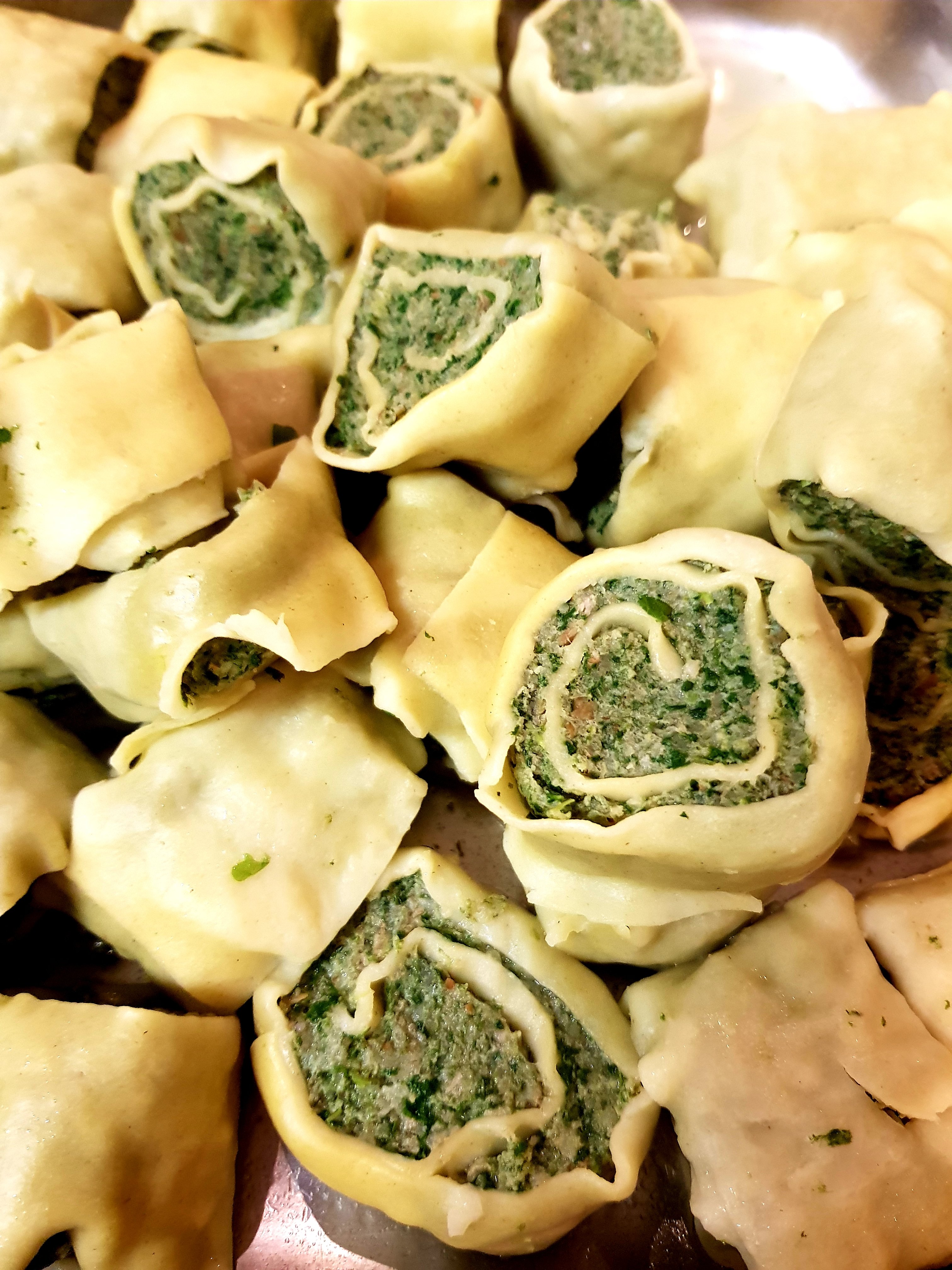 Homemade stuffed pasta pockets arranged on a tray