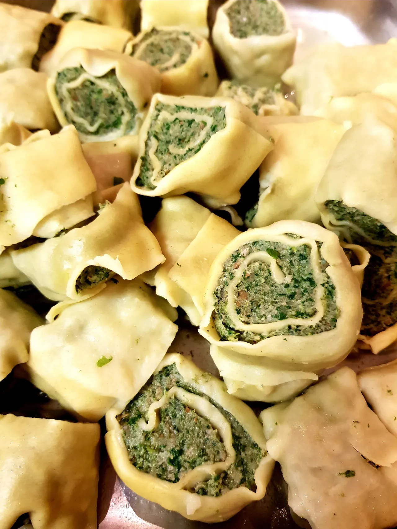 Homemade stuffed pasta pockets arranged on a tray