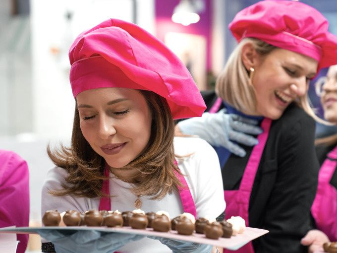 A woman smelling freshly coated chocolates