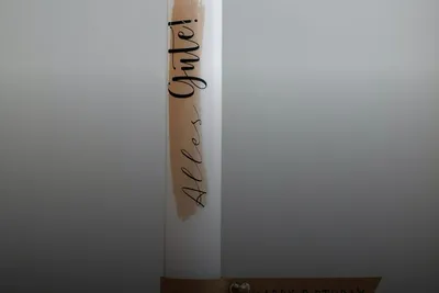 Christening: decorated baptism candle with the lettering “Alles Gute!”