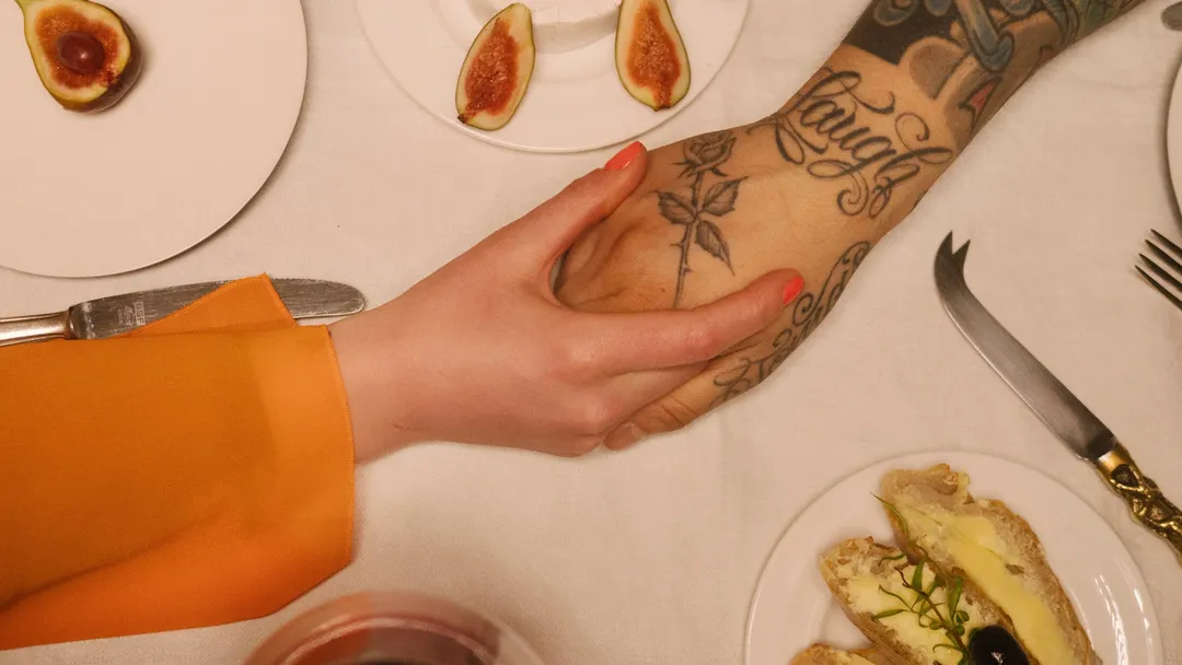 A couple holding hands during a meal