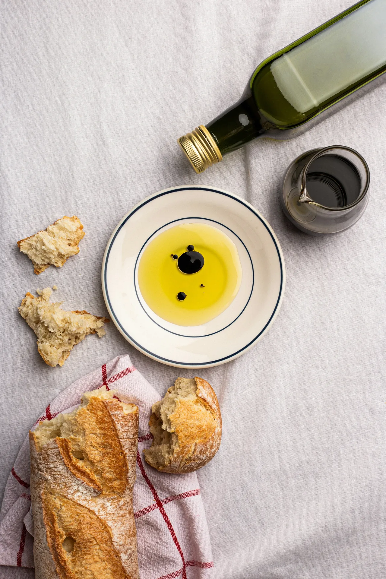 Multiple small, blue glass cups containing olive oil samples are lined up on a dark tabletop for a professional olive oil tasting and evaluation session.