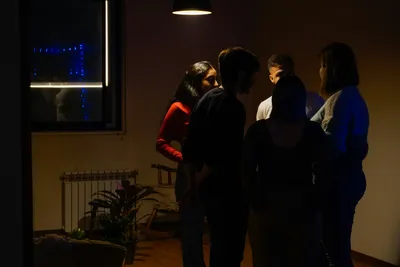 Friends gather in a dimly lit room