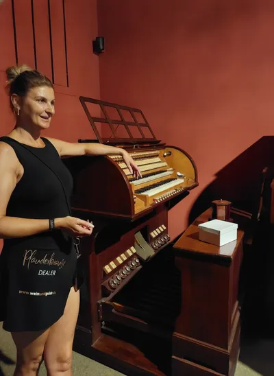 Woman in a black outfit explaining an old instrument