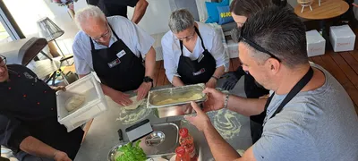 A group of people preparing pizza dough