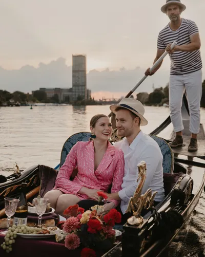 Couple cuddling in a rose-decorated gondola on the Spree in Berlin at dusk