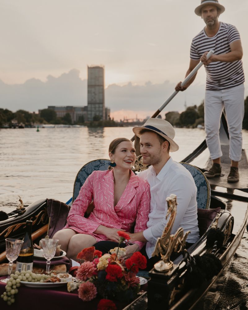 Couple cuddling in a rose-decorated gondola on the Spree in Berlin at dusk