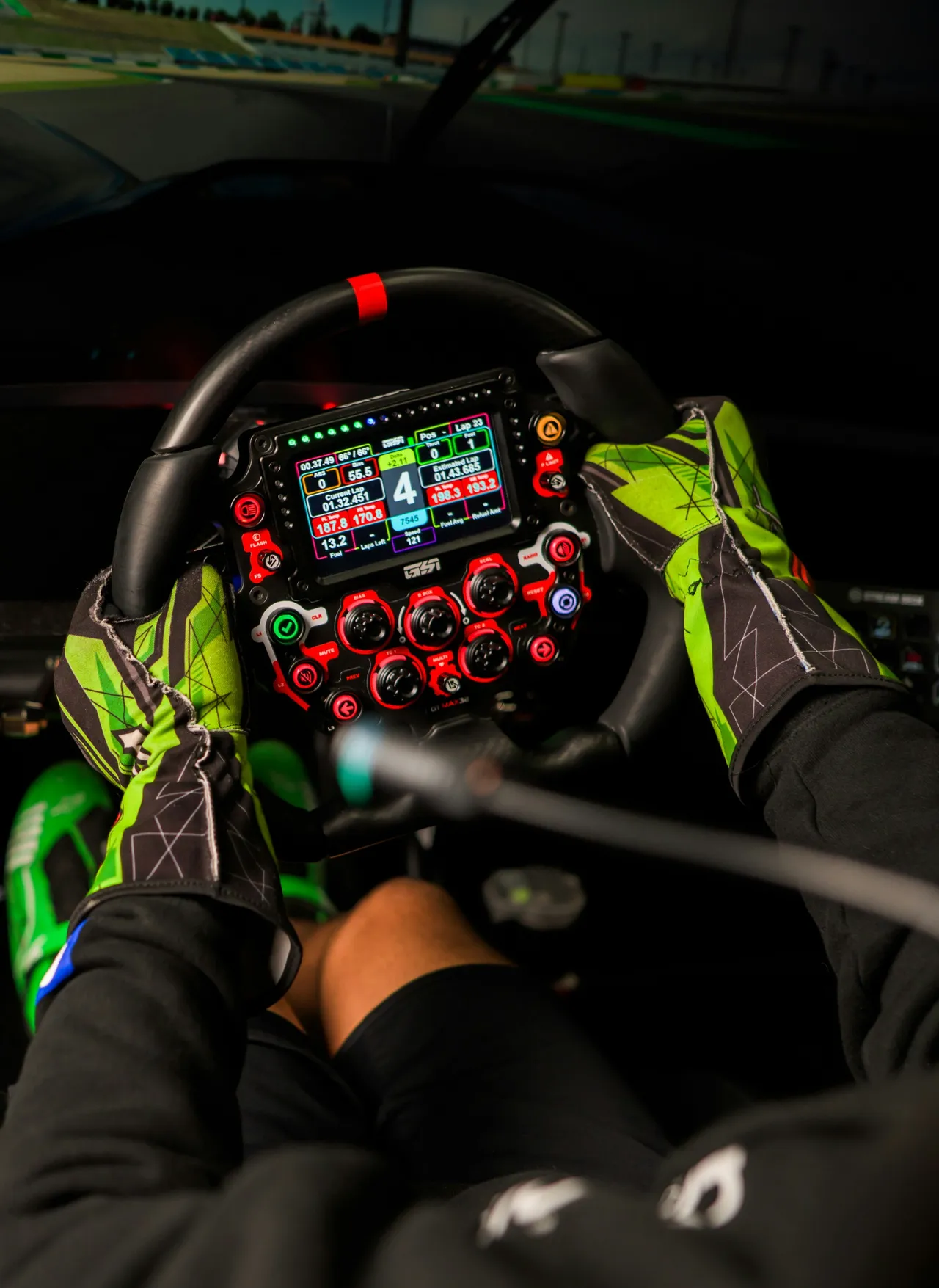 A high-end racing simulator setup featuring a professional bucket seat, three large wraparound monitors displaying a racetrack cockpit view, a racing steering wheel, and pedals.