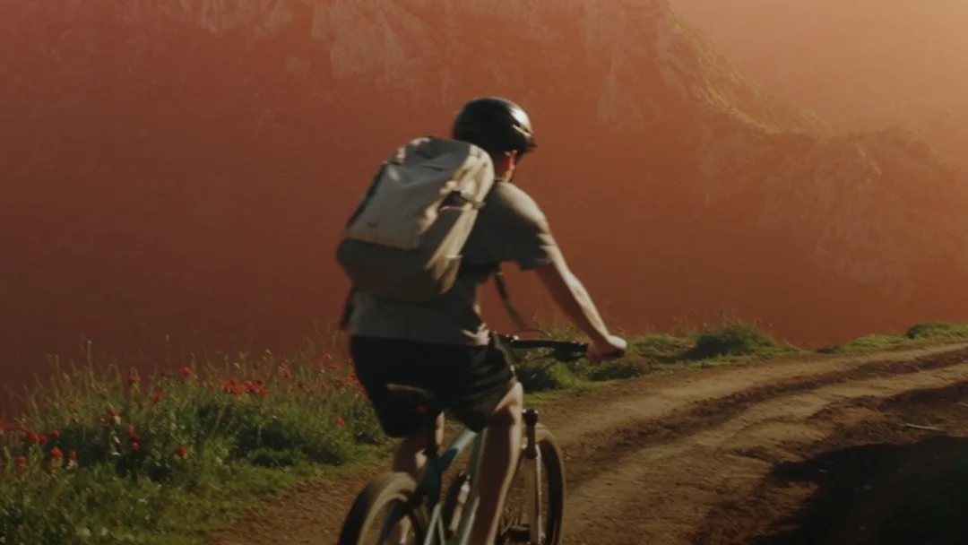 A person on a mountain bike in a mountain region at sunset