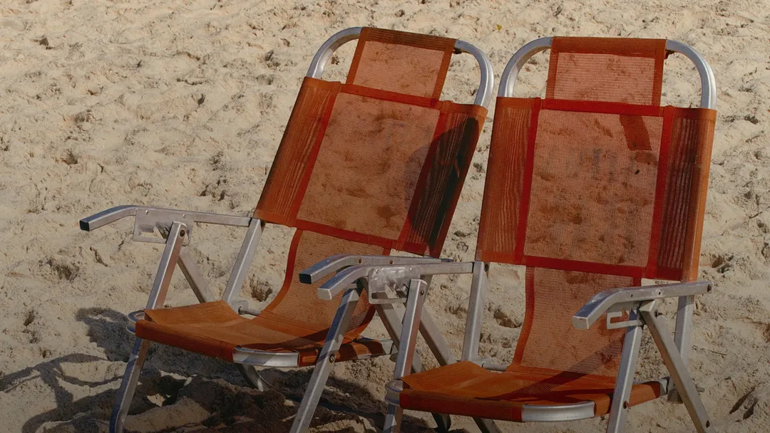 Two chairs next to each other on a beach