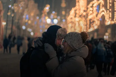 Gifts for couples: couple in winter hats embracing on a festively lit street