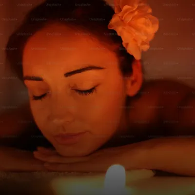 Gifts for your girlfriend: woman relaxing with closed eyes at a spa, flower in her hair