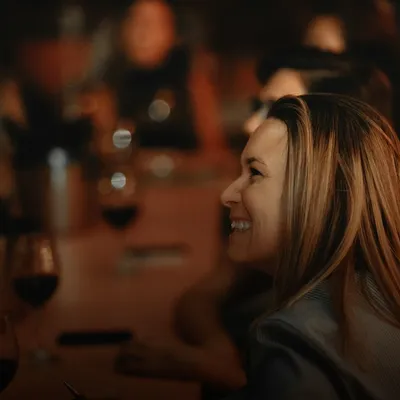 Gifts for women: smiling woman in a warmly lit restaurant